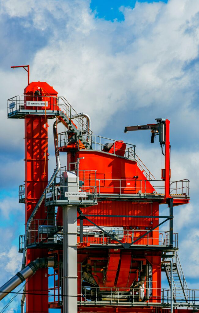 pexels-photo-26570528-26570528 Vivid red asphalt mixing plant tower against a bright blue sky in Tartu, Estonia.