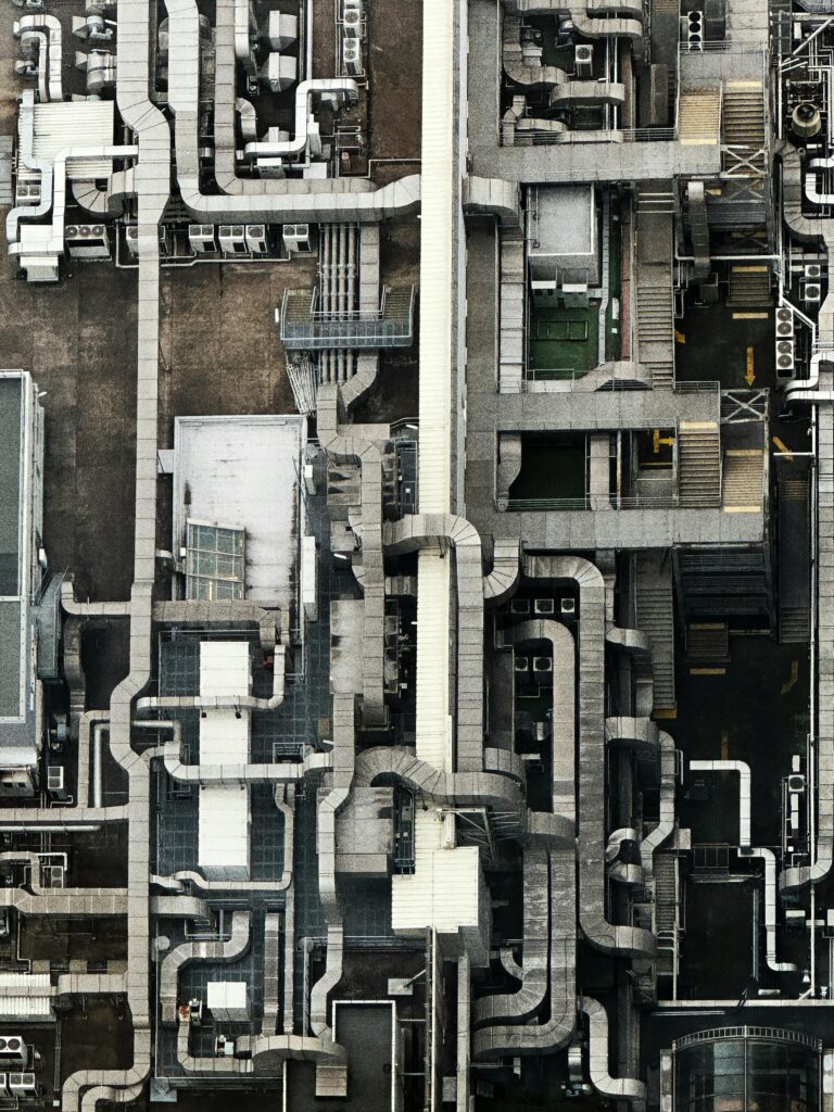 Aerial view showing an intricate network of industrial pipes and structures on a rooftop.